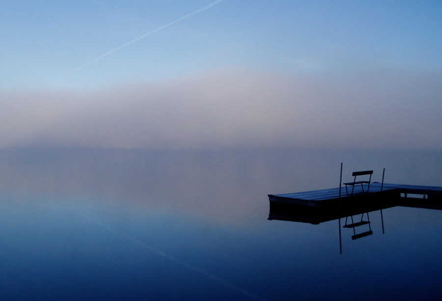 A misty lake at dawn with a small dock and bench, annotated with detection boxes